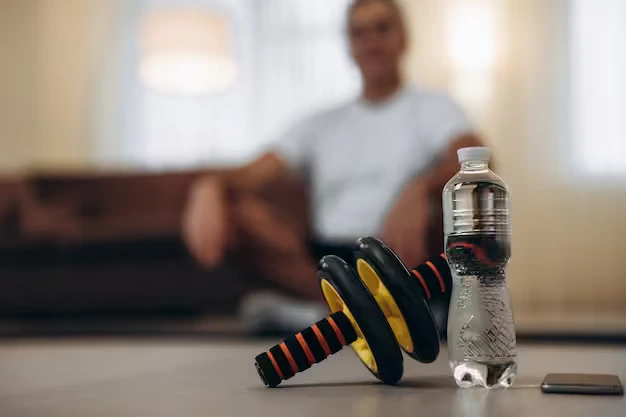 Post-workout recovery setup featuring an ab roller and water bottle alongside recovery devices.