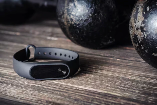 A black fitness band representing modern health trackers on a wooden surface.
