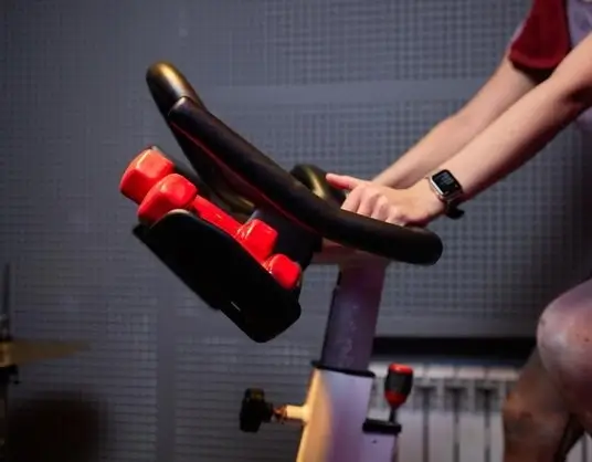Person using a stationary bike, a low-impact exercise equipment ideal for home cardio workouts.