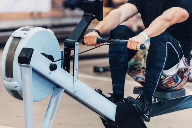 Person using a rowing machine, a low-impact exercise equipment for a full-body cardio workout.
