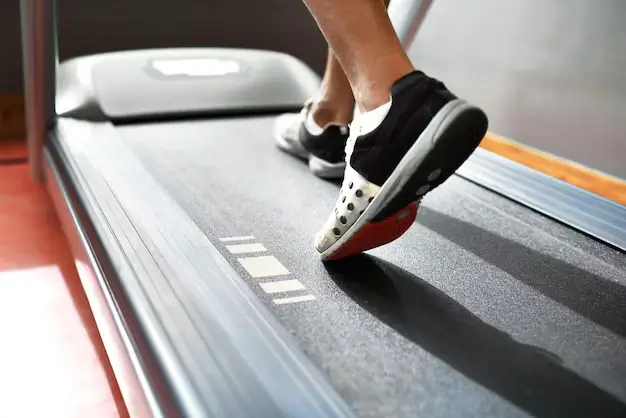 Person walking on a treadmill, a low-impact exercise equipment designed for joint-friendly cardio.