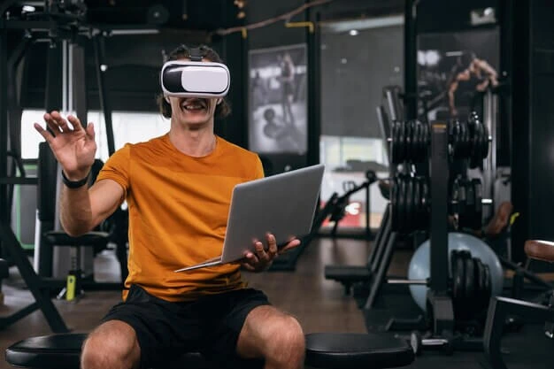 A man using a VR headset in a gym, demonstrating the role of virtual reality in technology in fitness.