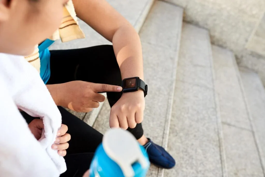 A person using a smartwatch to track fitness data with health trackers.
