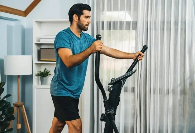 Man using an elliptical good for weight loss at home.