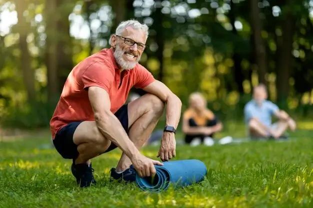 Senior man preparing for exercises for older adults outdoors.
