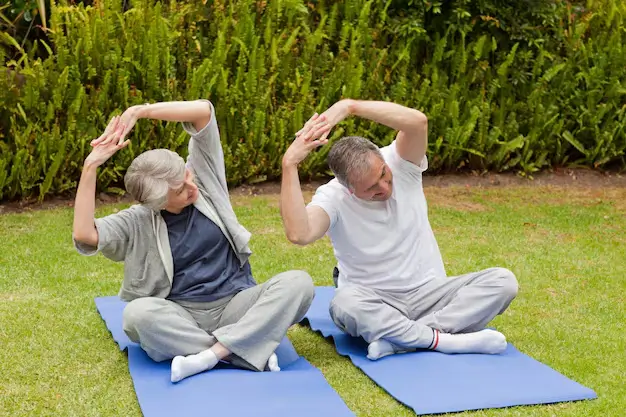 Older adults doing stretching exercises for older adults in the park.