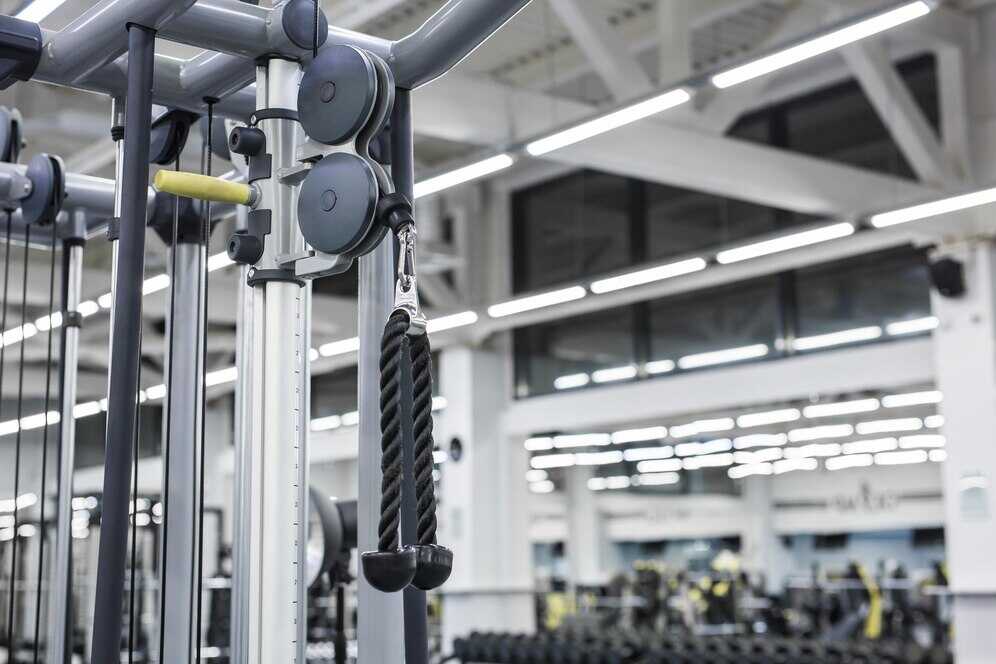 A close-up of a gym cable machine showing weight machines for beginners designed for safe resistance training.